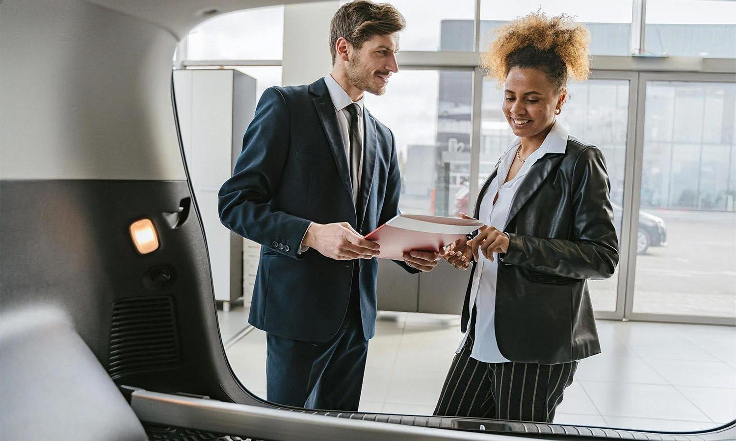 A person being assisted by a car dealer.